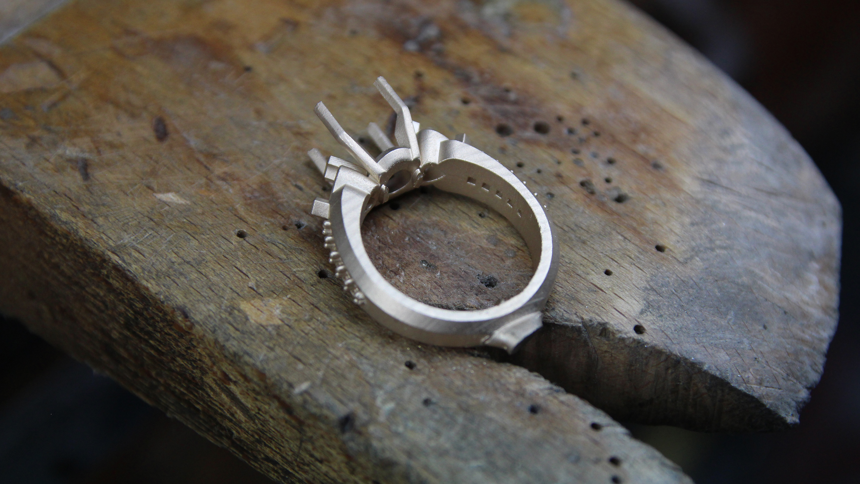 Anillo en bruto recién fundido con bebederos, sobre fondo negro